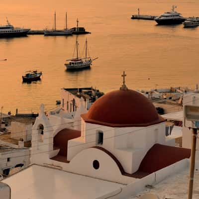 Red dome at sunset in Mykonos old harbour, Greece