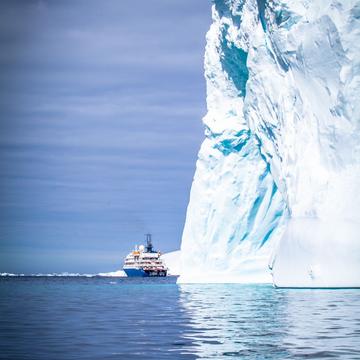 Small Ship large Iceberg Antarctica, Antarctica