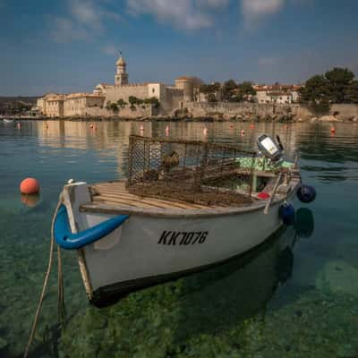 Vrbnik boat with walled city behind, Croatia