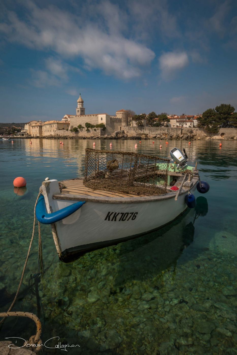 Vrbnik boat with walled city behind, Croatia