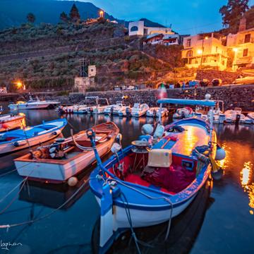 Fishing boats with old storage behind Malfa Salina, Italy