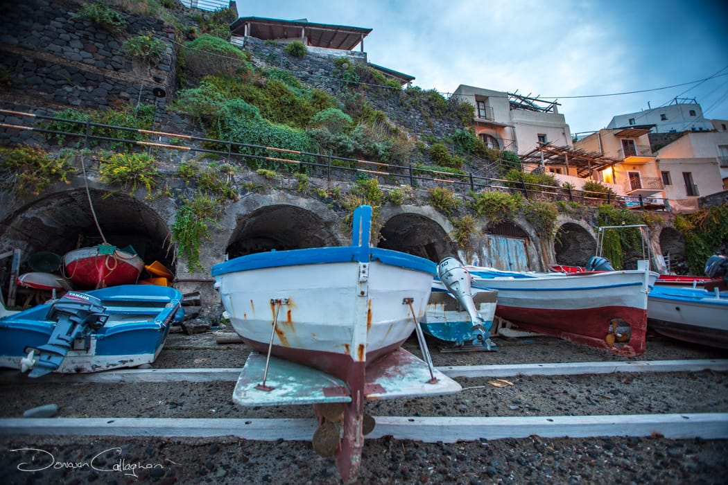 Fishing boats with old storage behind Malfa Salina, Italy