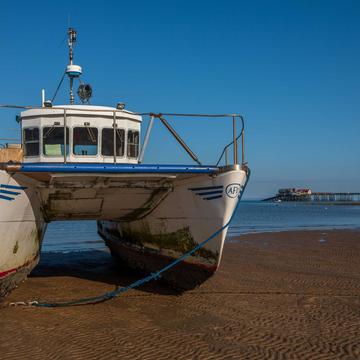 Double hull boat with Mumbles Pier in the background Wales, United Kingdom