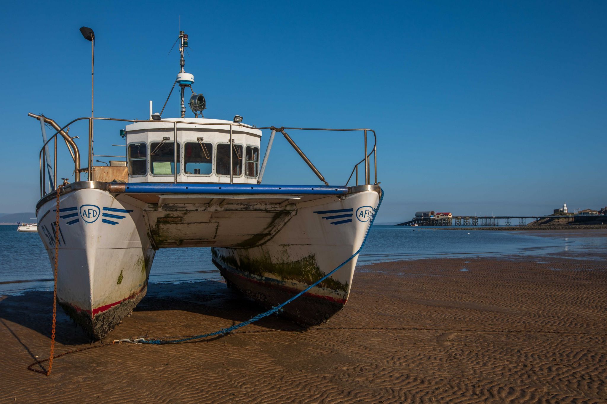 Double hull boat with Mumbles Pier in the background Wales, United Kingdom