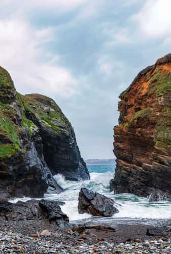 The incoming tide reaches a secluded pebble beach