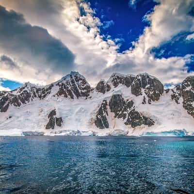 Zodiac with snow covered Island behind, Antarctica