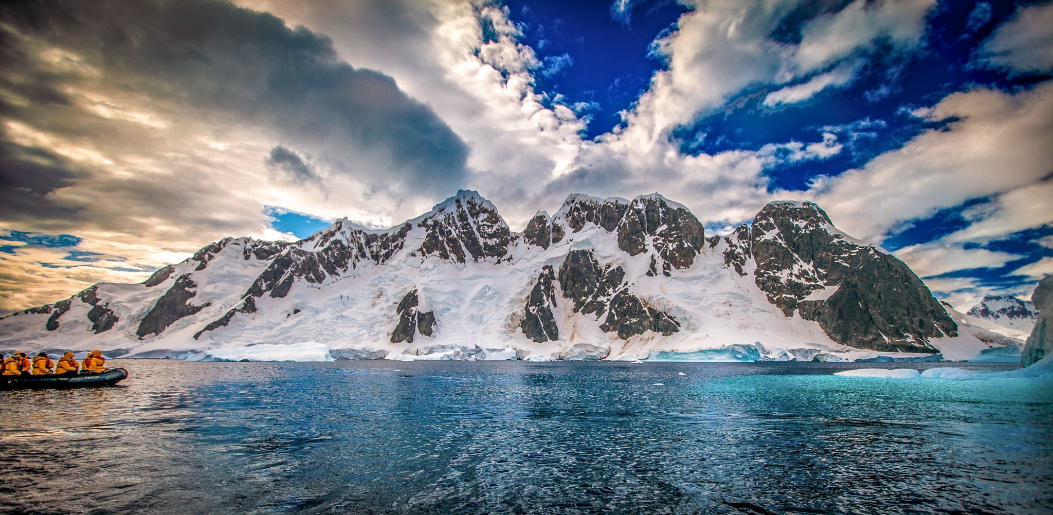 Zodiac with snow covered Island behind, Antarctica