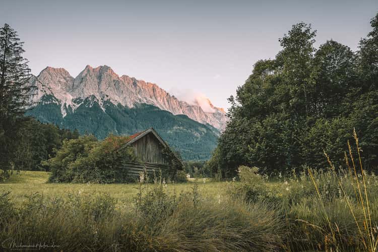 Rustic cabin in front of the Zugspitze in the evening glow