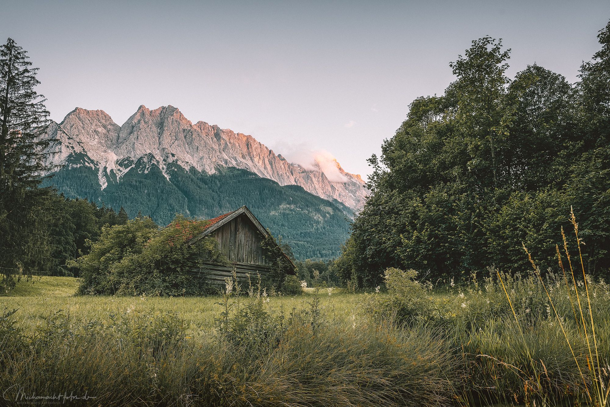 Rustic cabin in front of the Zugspitze in the evening glow, Germany
