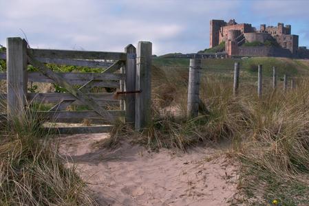 View at dawn of Bamburgh Castle from the beach and rocks