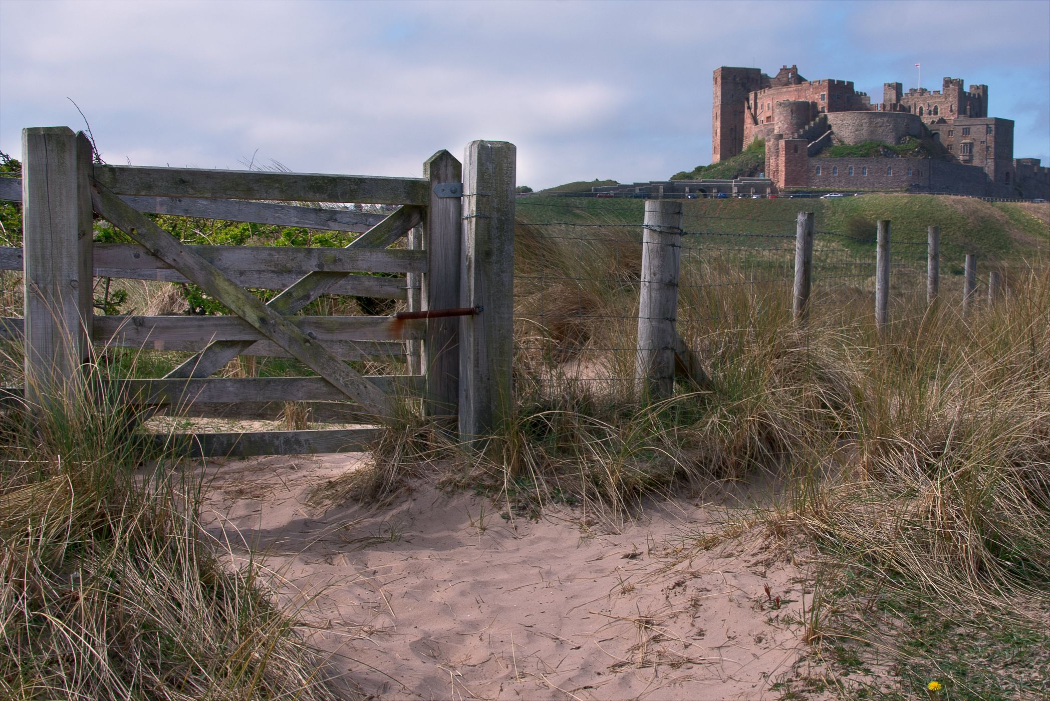 View at dawn of Bamburgh Castle from the beach and rocks, United Kingdom