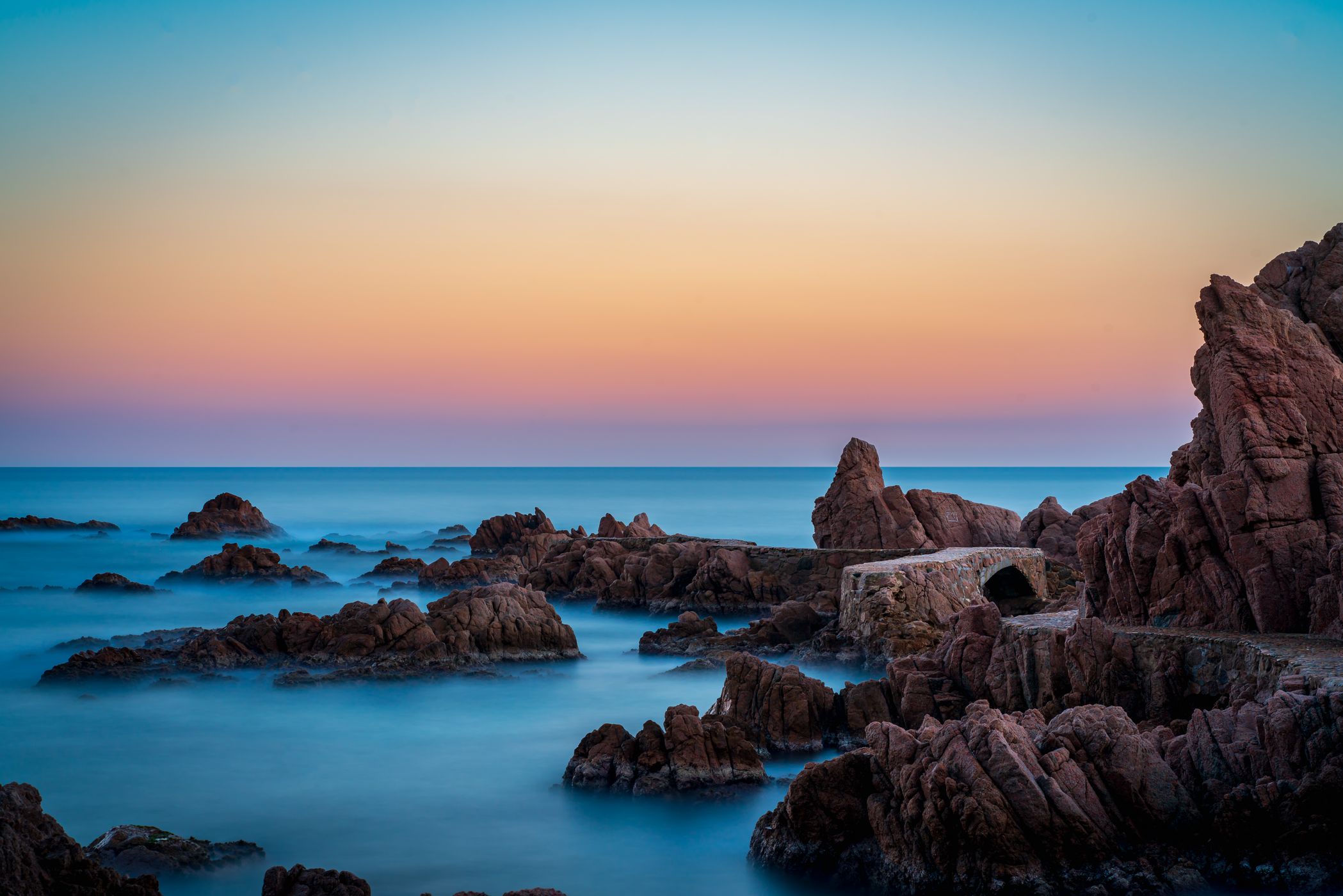 Evening view of the bridge on the rocks of Canyet de Mar, Spain