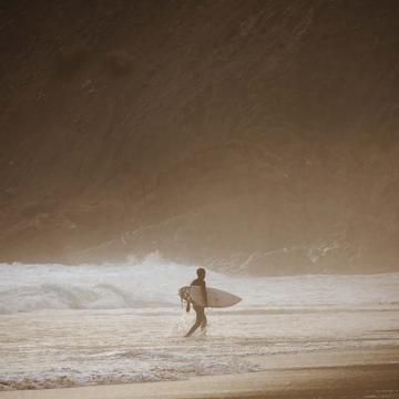 Surfer at Praia da Arrifana, Western Algarve, Portugal