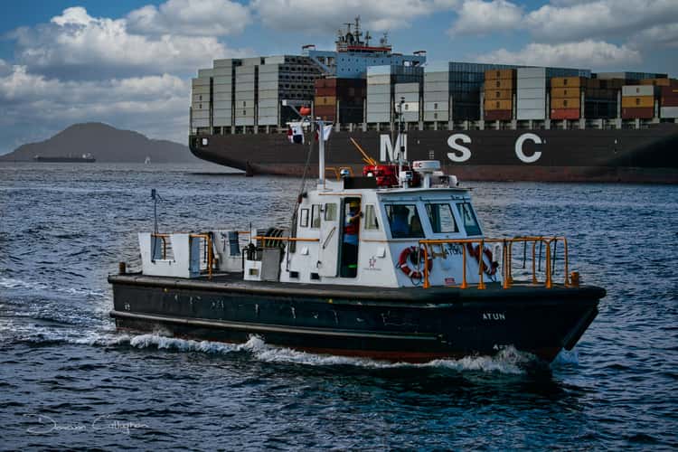 Tug and Ship about to enter Panama Canal,  Panama