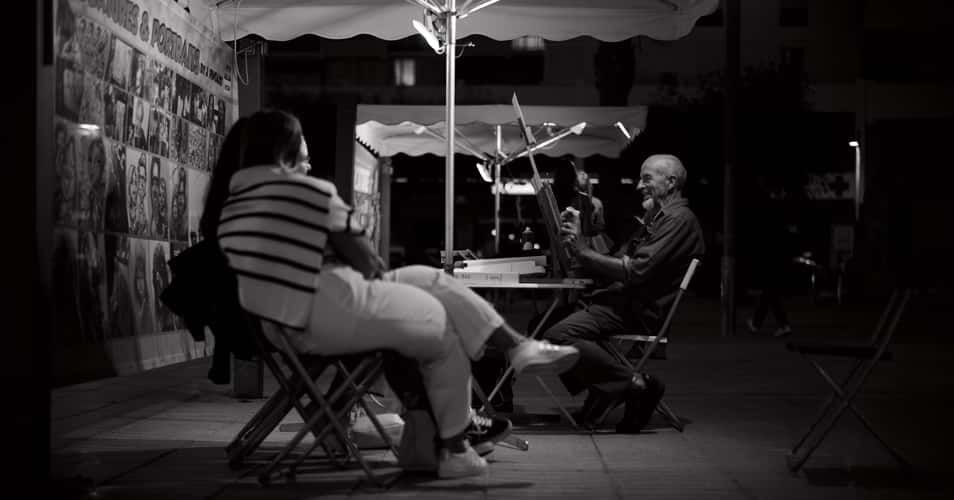 Artist drawing portraits near the harbor