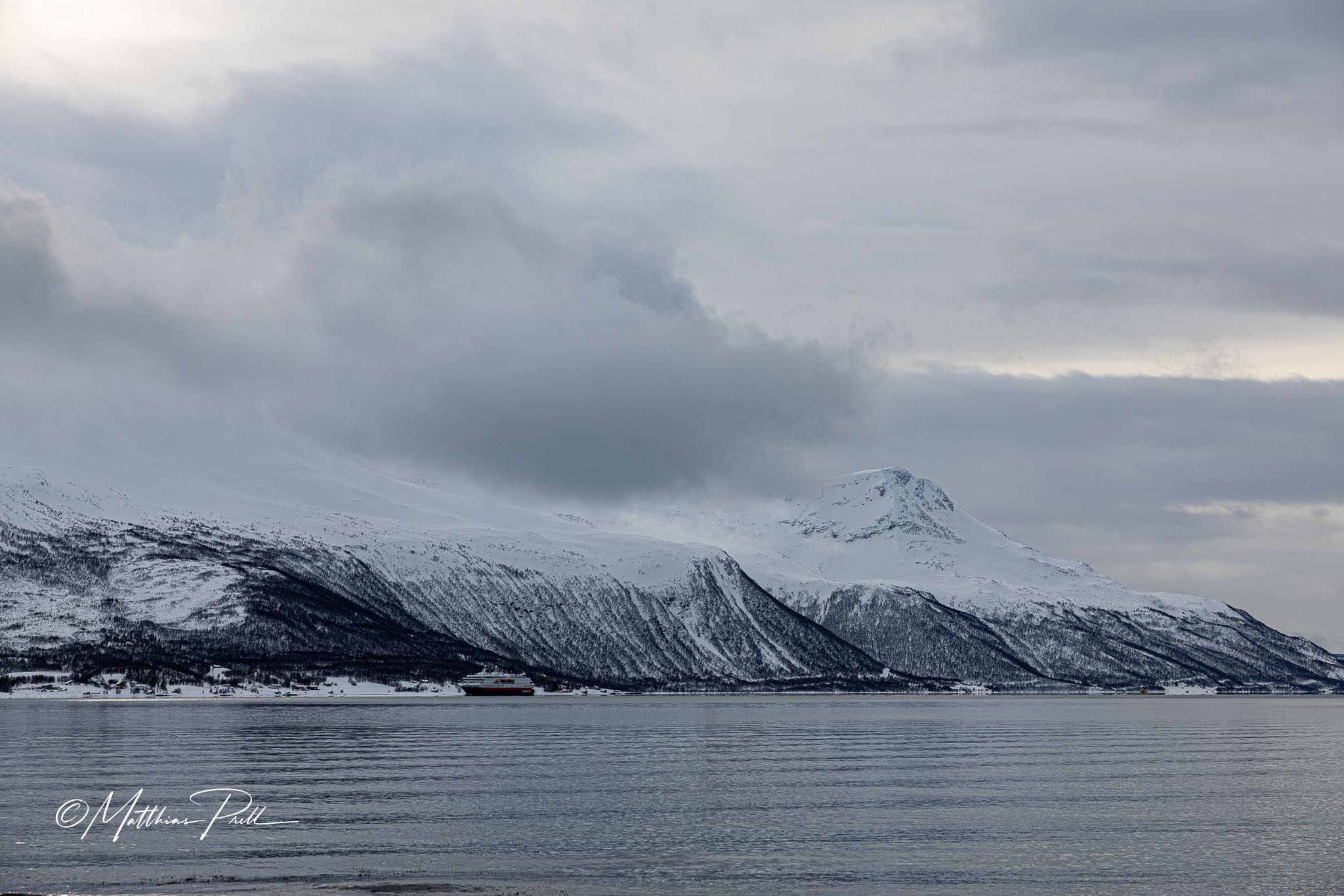 Red hut in front of fjord and mountain, Straumsbukta, Norway