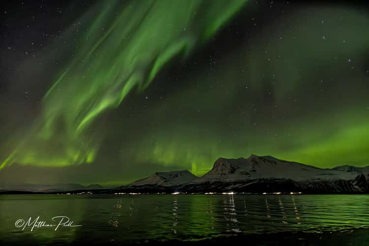 Polarlicht über Bergen und Fjord in der Region Tromsø