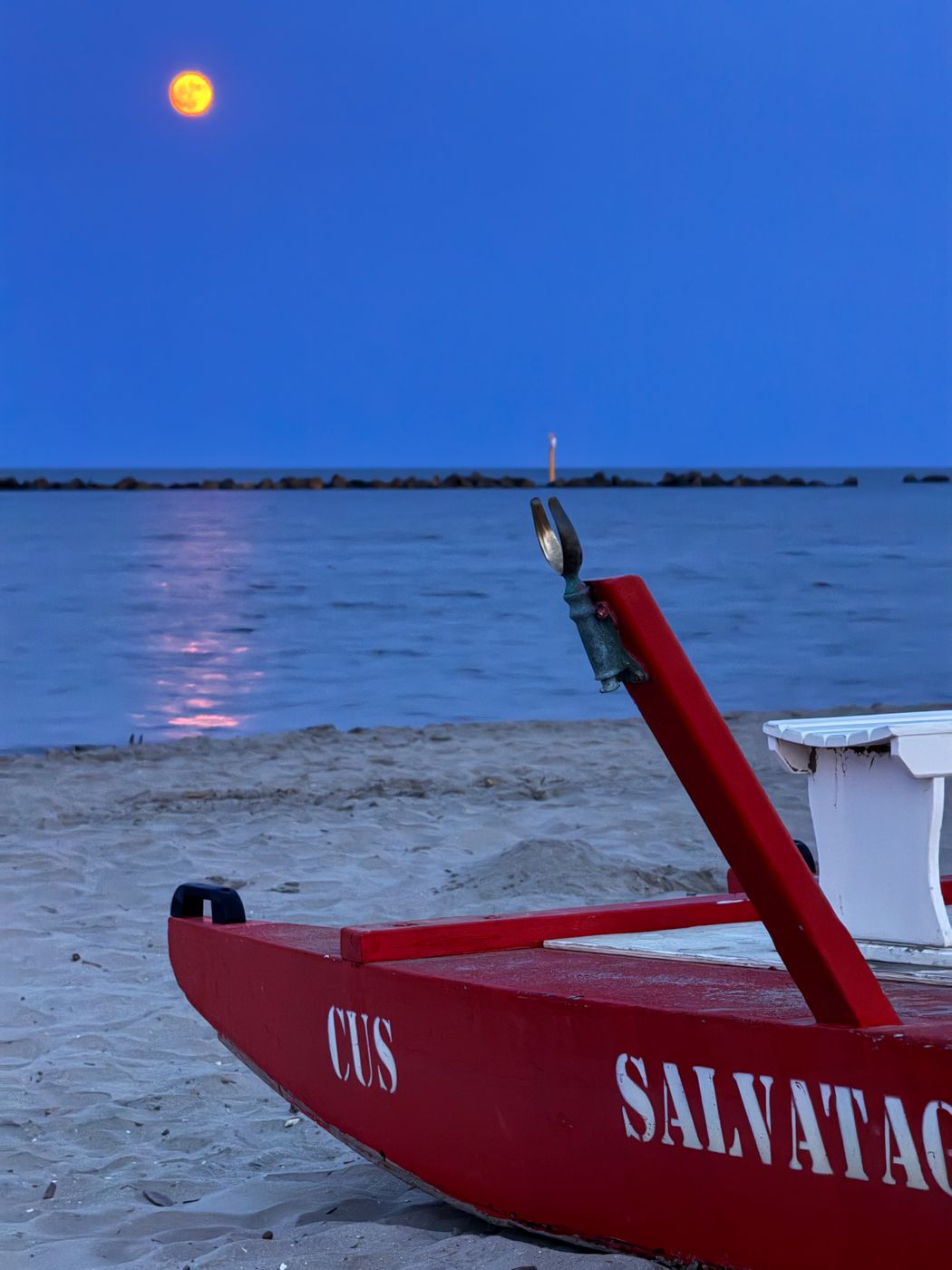 Lifeboat on the beach at full moon, Italy