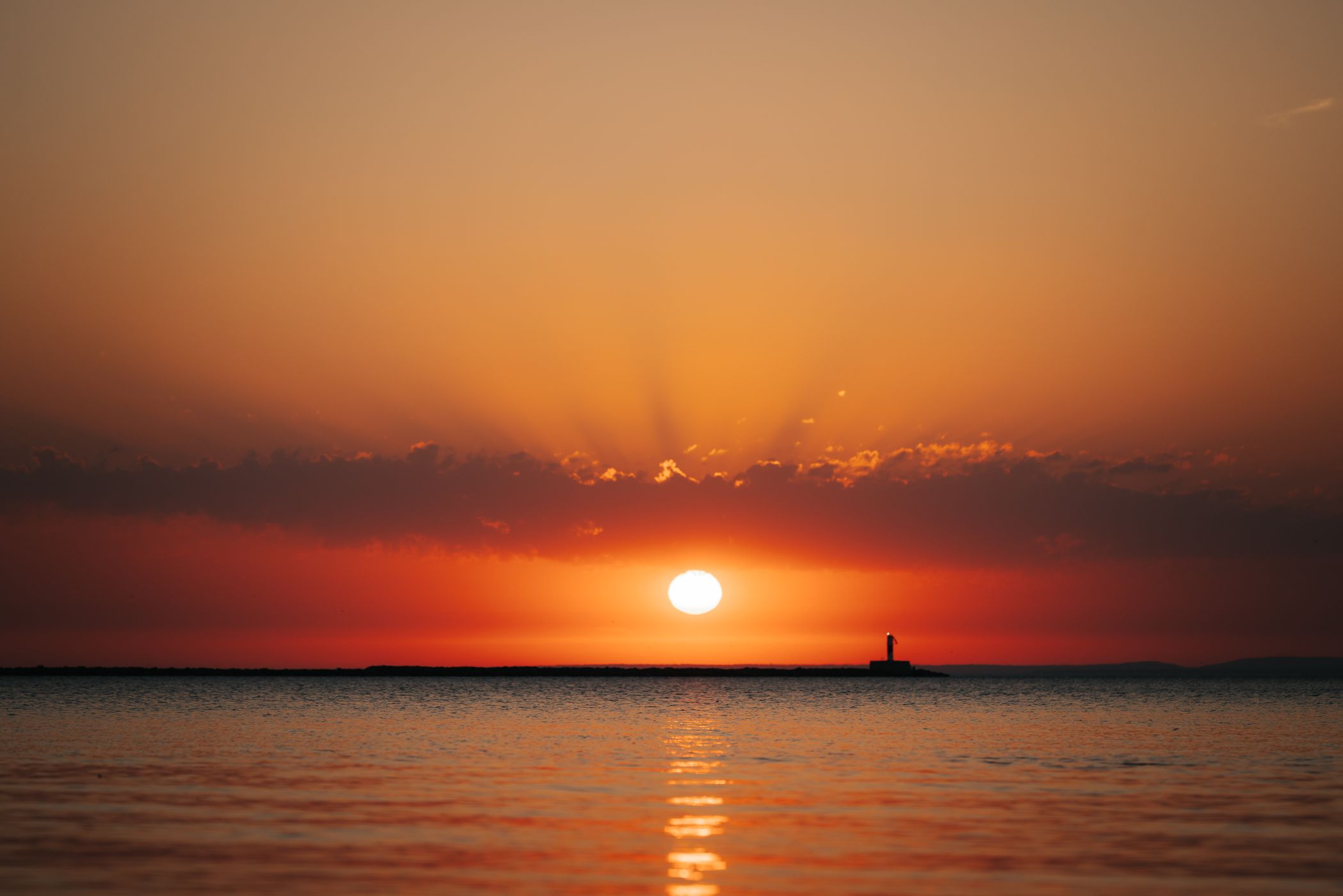 Sunrise at Marquette beach towards Breakwater Light, USA