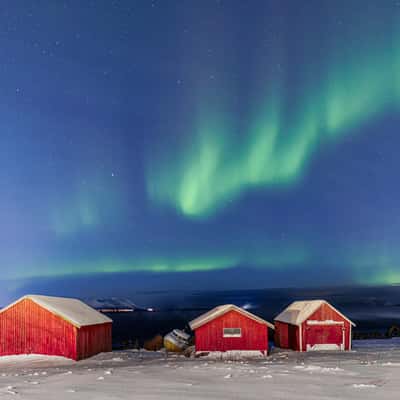 Rote Hütten mit Nordlichtern in Sandstrand, Norway