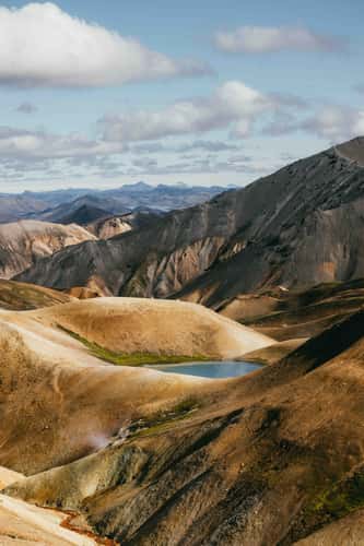Small blue pond, sheep, structures at Laugavegur trail